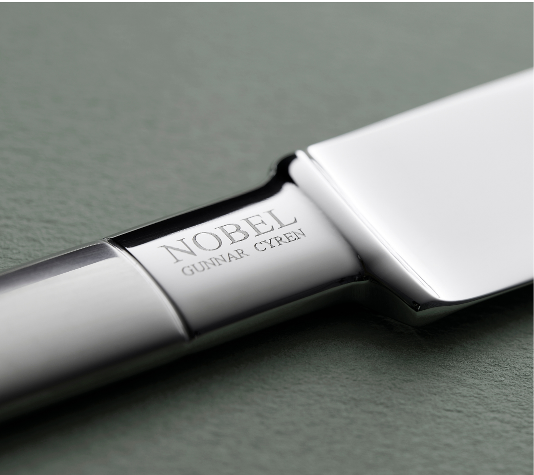 Close-up of a silver knife with Gense 'Nobel' branding on a gray background