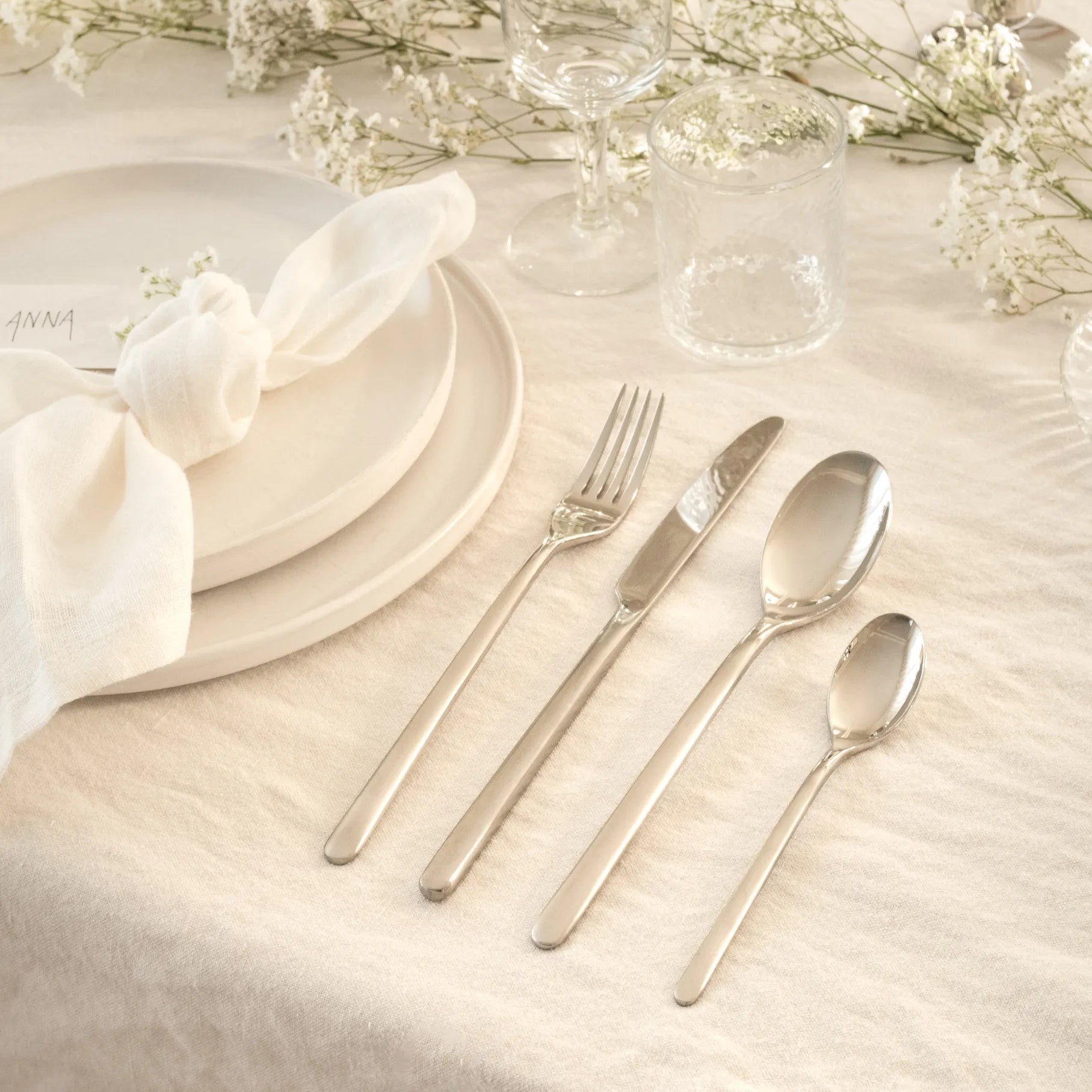 Gense Still Collection cutlery set on a light-colored tablecloth with decorative elements.